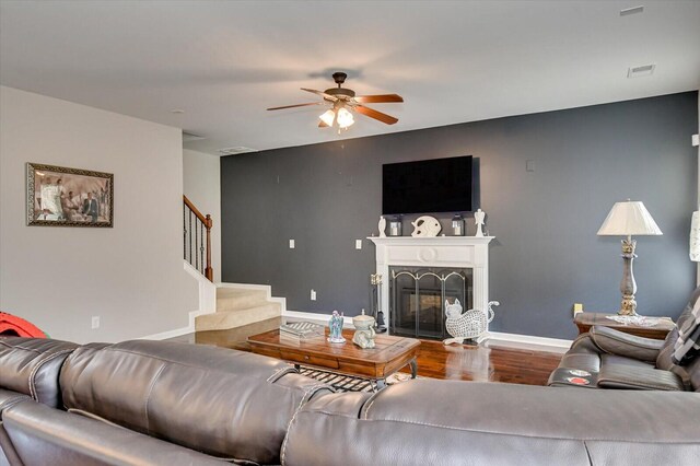 living room with ceiling fan, hardwood / wood-style floors, and a high end fireplace