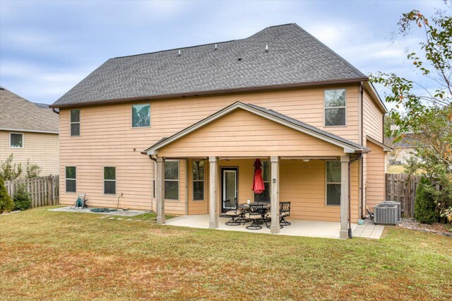 rear view of property featuring a lawn, central AC, and a patio