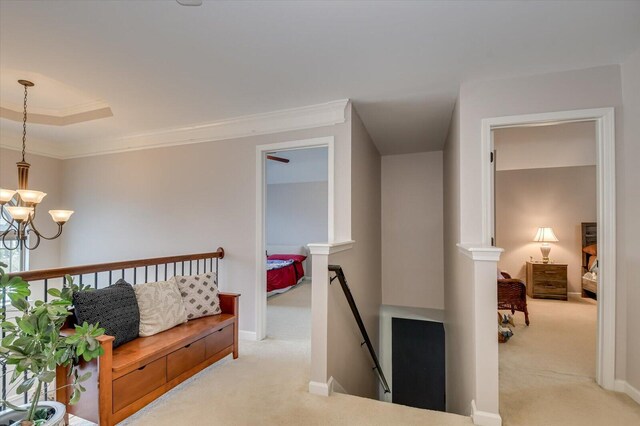 corridor with light carpet, crown molding, and a notable chandelier