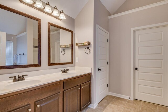 bathroom with tile patterned flooring, vanity, and vaulted ceiling