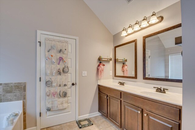 bathroom with a tub to relax in, tile patterned flooring, vanity, and vaulted ceiling