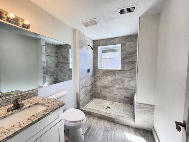 bathroom featuring visible vents, vanity, toilet, and a walk in shower