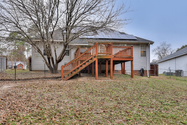 rear view of property featuring solar panels and a deck