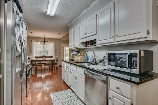 kitchen featuring a chandelier, appliances with stainless steel finishes, white cabinetry, and sink