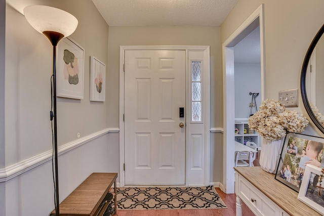 foyer entrance with a textured ceiling