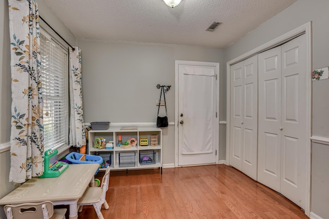 interior space featuring a textured ceiling and hardwood / wood-style flooring