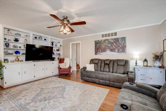 living room with ceiling fan, light hardwood / wood-style floors, crown molding, and a textured ceiling