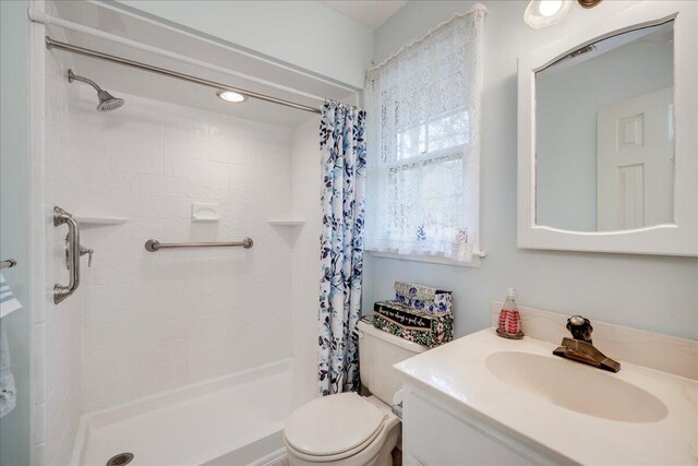 bathroom with vanity, toilet, and walk in shower