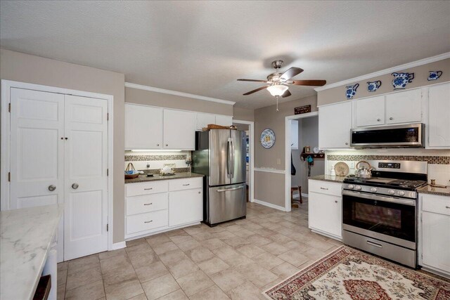 kitchen featuring ceiling fan, stainless steel appliances, tasteful backsplash, a textured ceiling, and white cabinets