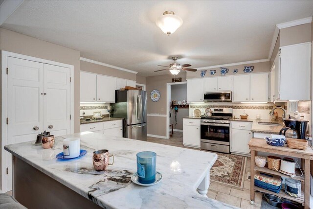 kitchen featuring tasteful backsplash, white cabinetry, sink, and appliances with stainless steel finishes