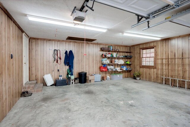 garage featuring wooden walls and a garage door opener