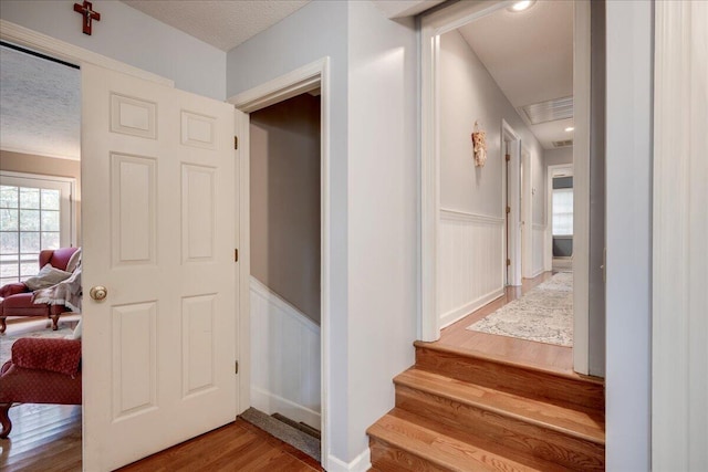 stairway with a textured ceiling and hardwood / wood-style flooring