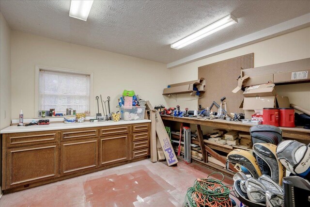 misc room with a workshop area and a textured ceiling