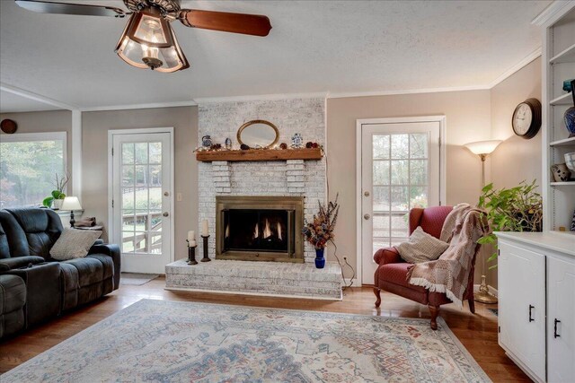 living room featuring light hardwood / wood-style floors, ceiling fan, a healthy amount of sunlight, and ornamental molding