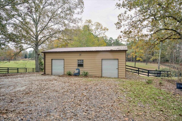 view of outbuilding featuring a rural view and a garage