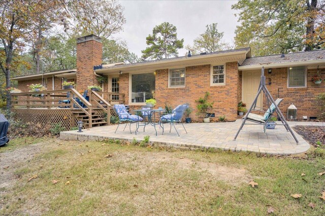 rear view of house featuring a patio area, a deck, and a yard