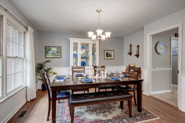 dining space with wood-type flooring and an inviting chandelier