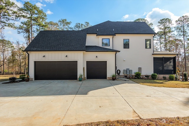 5416 Old Washington Rd, Evans, GA 30809 - view of side of property with concrete driveway, an attached garage, a shingled roof, and board and batten siding