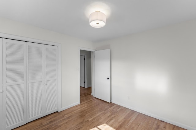 unfurnished bedroom with a closet and light wood-type flooring