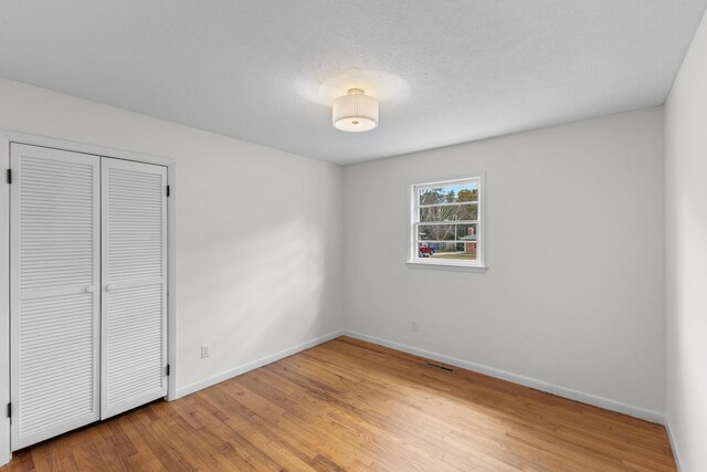 unfurnished bedroom featuring hardwood / wood-style floors and a closet