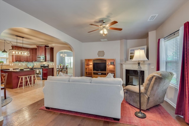 324 Congling Cir, Grovetown, GA 30813 - living room featuring arched walkways, plenty of natural light, a ceiling fan, and a glass covered fireplace