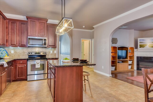 324 Congling Cir, Grovetown, GA 30813 - kitchen with appliances with stainless steel finishes, arched walkways, dark stone countertops, decorative backsplash, and a kitchen island