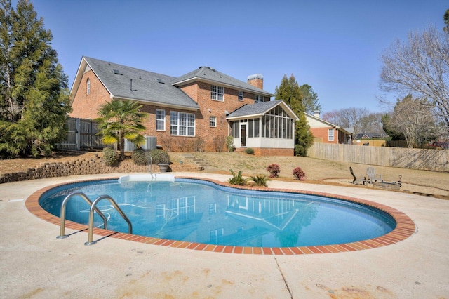 view of pool featuring central AC, fence, a sunroom, and a fenced in pool