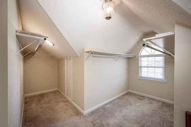 walk in closet featuring vaulted ceiling and carpet floors