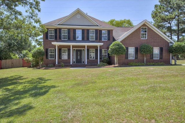 colonial-style house with a front yard and covered porch