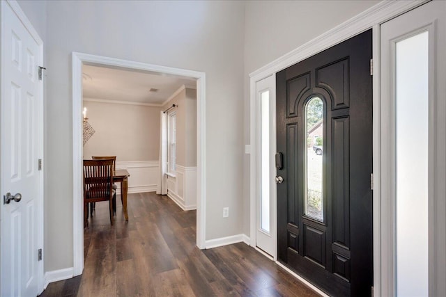 foyer entrance featuring ornamental molding and dark wood-type flooring