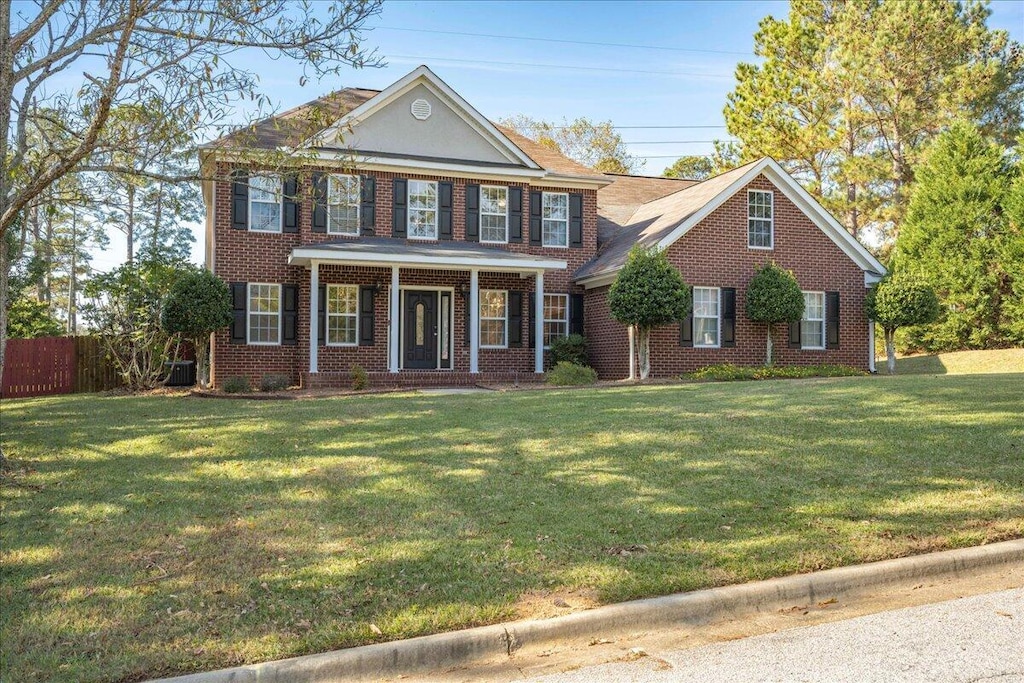 colonial inspired home featuring a front yard and central AC unit