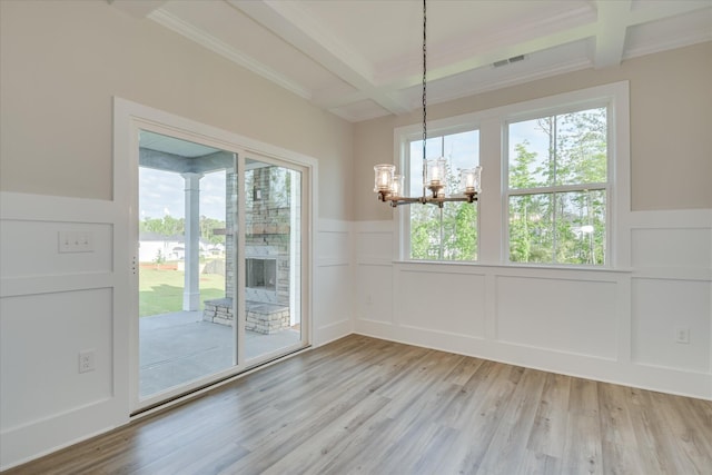 unfurnished dining area featuring a decorative wall, beam ceiling, and a notable chandelier
