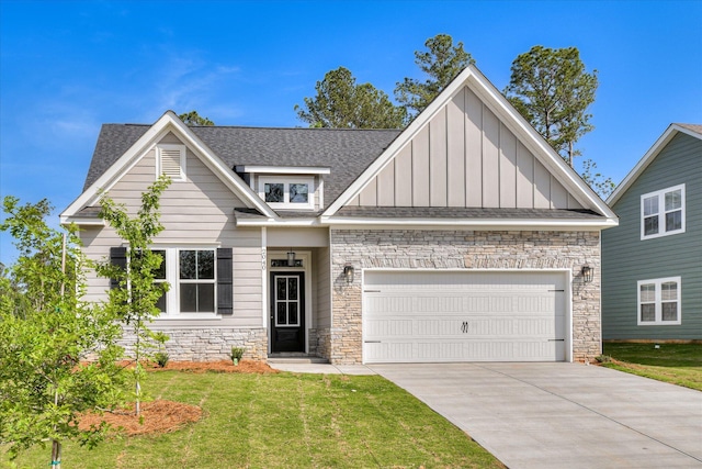 craftsman-style home featuring a front lawn, stone siding, board and batten siding, concrete driveway, and an attached garage