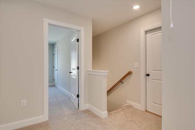 hall featuring light colored carpet, baseboards, an upstairs landing, and recessed lighting
