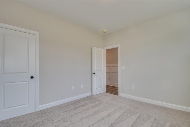 unfurnished bedroom featuring carpet floors and baseboards