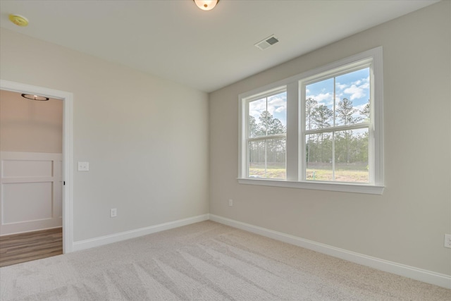 unfurnished room featuring carpet floors, baseboards, and visible vents