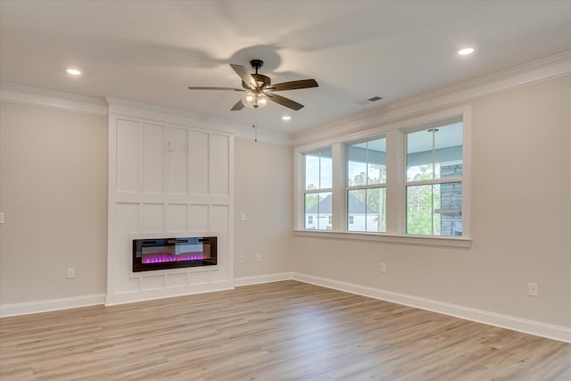 unfurnished living room with crown molding, a ceiling fan, a glass covered fireplace, and light wood-style flooring