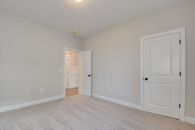 carpeted empty room featuring baseboards