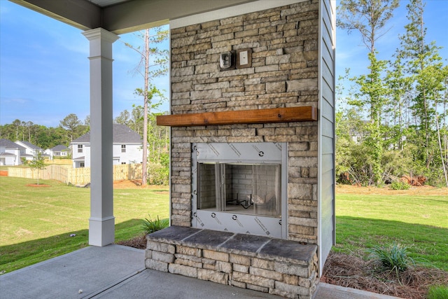 view of patio with an outdoor stone fireplace and fence