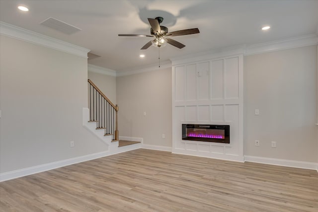 unfurnished living room featuring visible vents, ornamental molding, a glass covered fireplace, light wood-style floors, and a ceiling fan