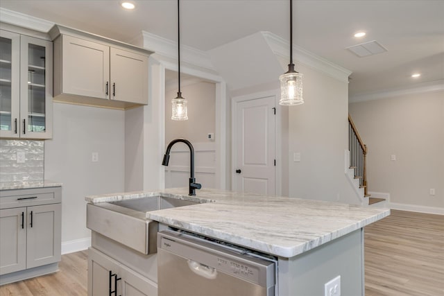 kitchen with a sink, gray cabinets, light wood-type flooring, ornamental molding, and dishwashing machine
