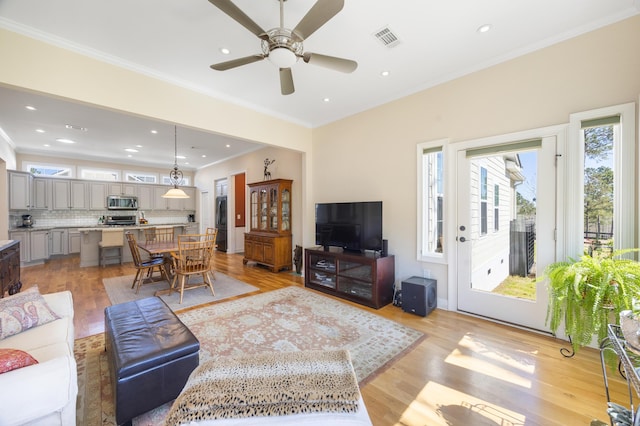 living room featuring light wood finished floors, visible vents, recessed lighting, and crown molding