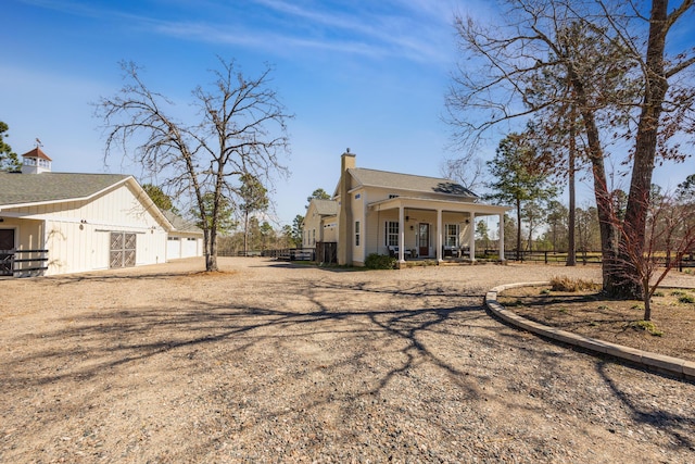 exterior space featuring a porch, fence, roof with shingles, and a chimney