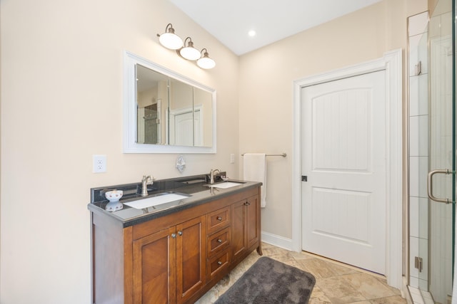 bathroom with a shower stall, double vanity, and a sink