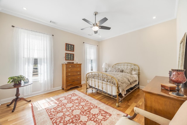 bedroom featuring visible vents, multiple windows, crown molding, and wood finished floors