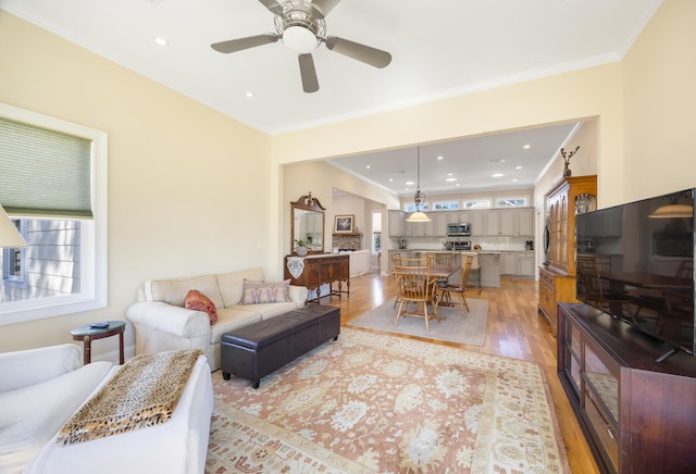 living room featuring recessed lighting, light wood-style floors, and crown molding