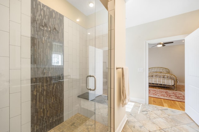 bathroom with tile patterned flooring, baseboards, a stall shower, and ceiling fan