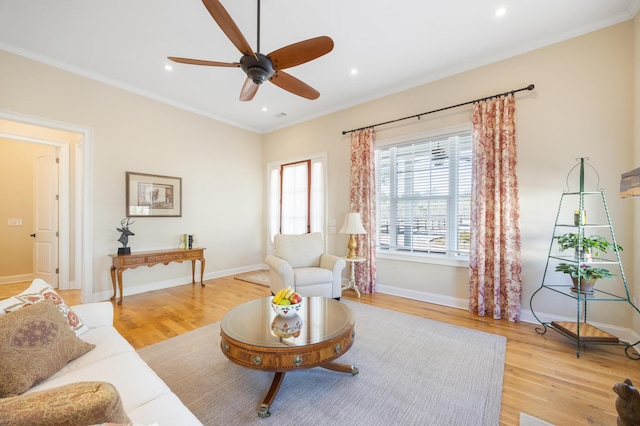 living area with crown molding, recessed lighting, baseboards, and light wood-type flooring