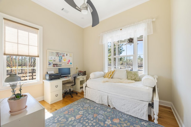 bedroom with light wood finished floors, visible vents, a ceiling fan, and baseboards