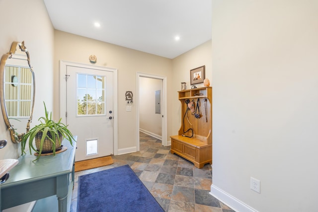 entrance foyer featuring electric panel, recessed lighting, stone finish floor, and baseboards